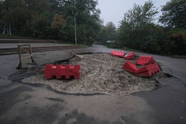 Alacakaranlıkta asfalt yolda hasar görmüş. Mühendislik otoyollarının tamiri. Kötü yol. Yol boyunca terk edilmiş yol, özellikle tehlikeli çukurlar. Tehlikeli bir yol..