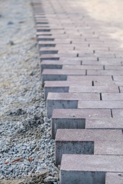 Terasa, yola ya da kaldırıma kaldırım taşları döşemek ve yerleştirmek. Kaldırımlar için taş kullanan işçiler