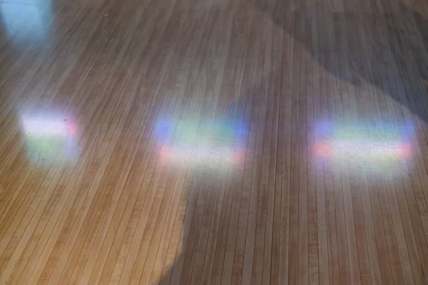 Rainbow reflection on the laminate floor. Light dispersion.