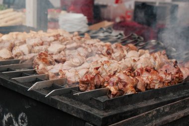 Kızarmış etli biftek, baharat ve otlarla birlikte, yanan kömürlerin içinde, bbq ızgarası, alevler ve duman. Izgara çizgili sulu biftek piknik kutlaması için hazır. Barbekü ızgarası