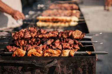 Kızarmış etli biftek, baharat ve otlarla birlikte, yanan kömürlerin içinde, bbq ızgarası, alevler ve duman. Izgara çizgili sulu biftek piknik kutlaması için hazır. Barbekü ızgarası
