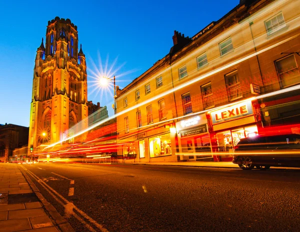Low angle shot of Wills Memorial Building with the glowing light trails of passing traffic in the foreground