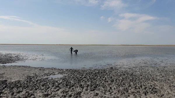 Bir erkek ve bir kadın cesedi nehir kıyısına terapi amaçlı çamurla süpürüyor..