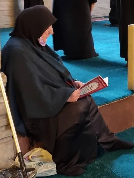   Siyah elbiseli bir kadın tapınakta yerde oturuyor.