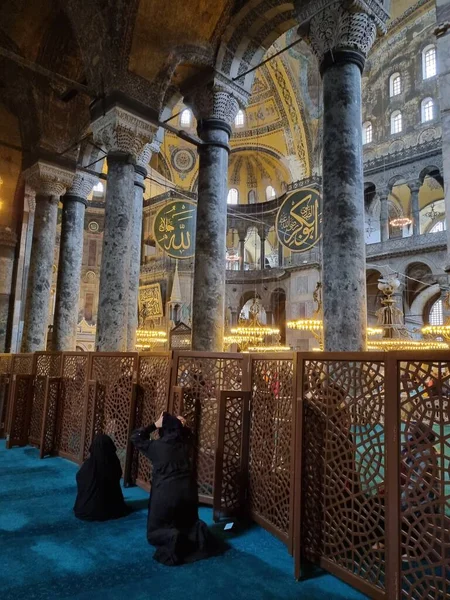   Siyah elbiseli bir kadın tapınakta yerde oturuyor.