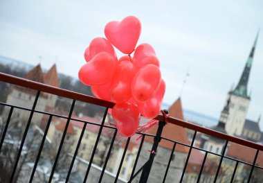 Avrupa Tallinn Eski Şehri 'nin panoramik manzarasının arkasındaki Kırmızı Kalpler Balonları. Sevgililer Günü aşk hikayesi