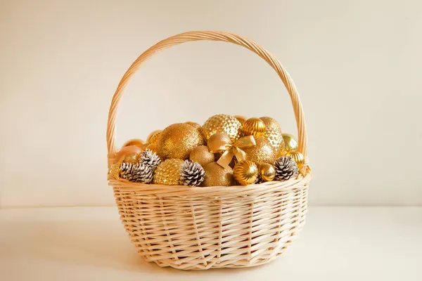 Enorme cesta de vime cheio até o topo com bolas de ouro para decorar abeto de Natal ou apartamento — Fotografia de Stock