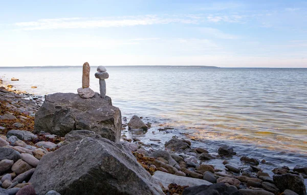 Stenen balans, zen steentjes stapel over de blauwe zee in Estland. Blauwe lucht aan zonnige kust in de zomer. — Stockfoto