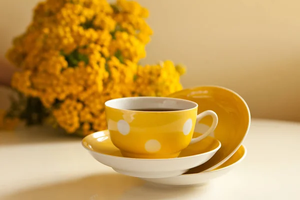 Żółta lewitacja z czarną herbatą. zestaw do herbaty retro z kwiatami. kubek i talerze vintage na stole — Zdjęcie stockowe