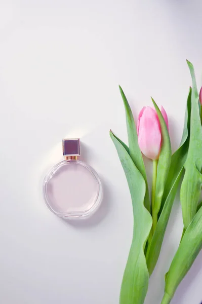 Kruchość i różowa kompozycja tulipanowo-romantyczna. butelka perfum i koperta. projekt pocztówki — Zdjęcie stockowe