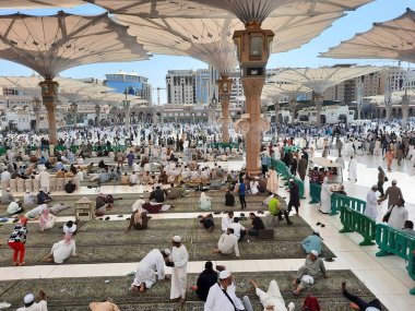 Mescid Al Nabawi, Madinah Cuma namazından sonra, çok sayıda hacı Mescid Al Nabawi 'nin dışındaki avluda toplandı. Ziyaretçiler, caminin dışındaki avlular ve elektronik şemsiyeler de görülebilir.