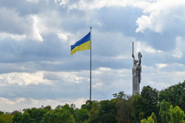 Monument to Motherland and the flag of Ukraine in the city of Kyiv 