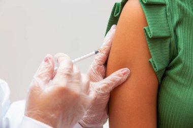 Nurse applying the vaccine against covid 19 and the new variant omicron
