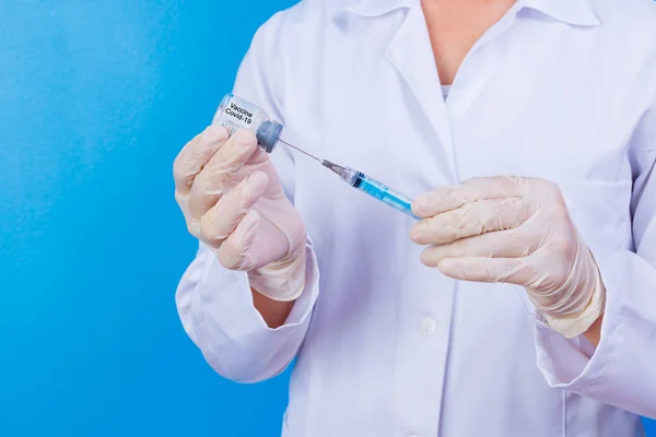 nurse holding covid 19 vaccine and syringe. Coronavac. Vaccination against the new Corona Virus Vacine-Covid19: A syringe being drawn up with Vacine-Covid 19.