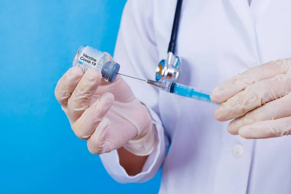 nurse holding covid 19 vaccine and syringe. Coronavac. Vaccination against the new Corona Virus Vacine-Covid19: A syringe being drawn up with Vacine-Covid 19.