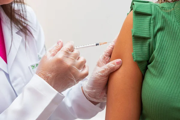 Nurse applying the vaccine against covid 19 and the new variant omicron