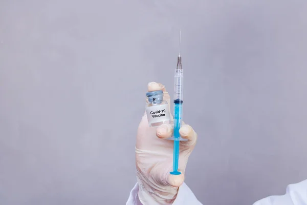 nurse holding covid 19 vaccine and syringe. Coronavac. Vaccination against the new Corona Virus Vacine-Covid19: A syringe being drawn up with Vacine-Covid 19.