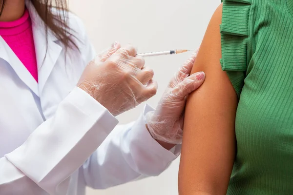 Nurse applying the vaccine against covid 19 and the new variant omicron