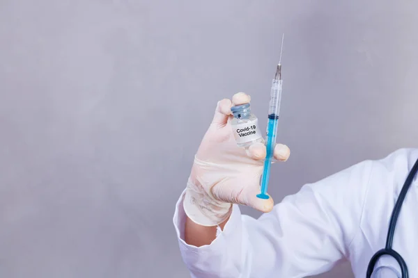 nurse holding covid 19 vaccine and syringe. Coronavac. Vaccination against the new Corona Virus Vacine-Covid19: A syringe being drawn up with Vacine-Covid 19.
