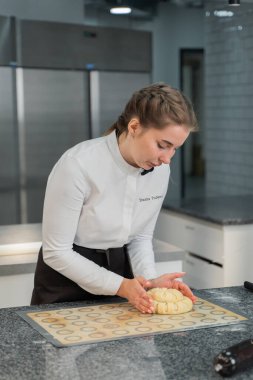 Kız mutfakta turta pişiriyor.