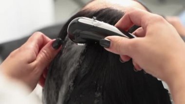 Kozmetik uzmanı ameliyatlar için kızın kafasını şampuanla yıkar. Siyah saçlı. artı boyut.