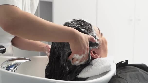 Cosmetologist Lava Cabeça Menina Com Xampu Novos Procedimentos Cabelo Preto — Vídeo de Stock