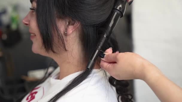 Der Friseur Wickelt Die Haare Mit Einem Lockenstab Schwarze Haare — Stockvideo