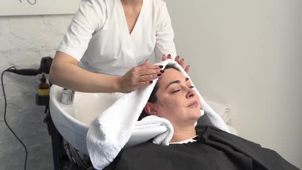 美容师用毛巾擦干病人的头发 黑头发 加尺寸 — 图库视频影像