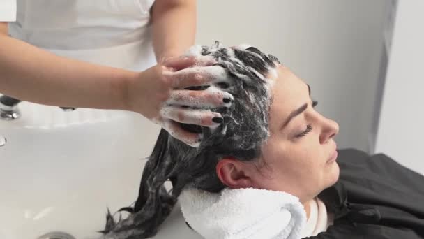 Cosmetologist Lava Cabeça Menina Com Xampu Novos Procedimentos Cabelo Preto — Vídeo de Stock