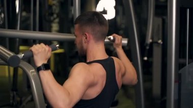 Adam spor salonundaki simülatörde sırtını sallıyor. koyu arkaplan