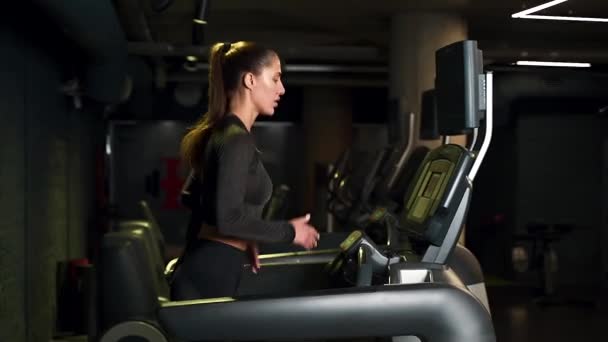 Μια Αθλήτρια Τρέχει Διάδρομο Στο Γυμναστήριο Σκούρο Φόντο — Αρχείο Βίντεο