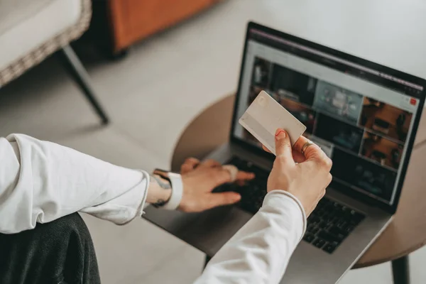 Bir kız, bir online mağazadan, odada bir banka kartıyla alışveriş yapıyor.