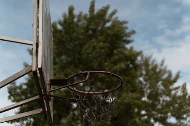 Sokak basketbolu potası. Gökyüzü ve ağaçların arka planına karşı