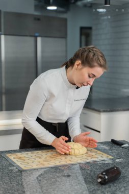 Kız mutfakta turta pişiriyor.