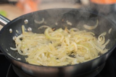 Soğanlar mutfakta kızartma tavasında kızartılır.