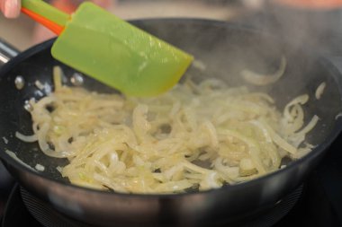 Soğanlar mutfakta kızartma tavasında kızartılır.