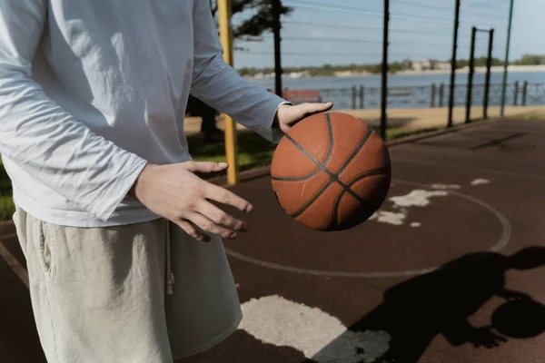 Tipo Sostiene Una Pelota Baloncesto Sus Manos Calle Cancha Baloncesto — Foto de Stock