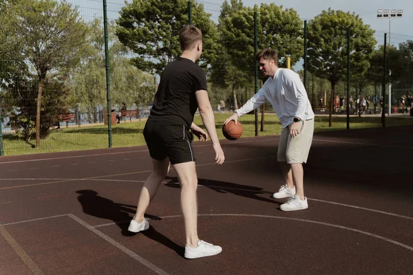 Kaksi Miestä Pelaa Koripalloa Ulkona Kentällä — kuvapankkivalokuva