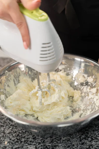 the cook beats the cream with a mixer