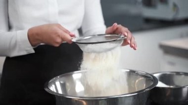 Bir kaseye un döken bir kız.