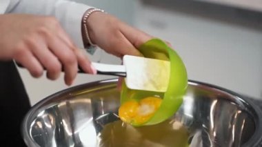 Şef krema yapmak için şekere yumurta sarısı ekler.