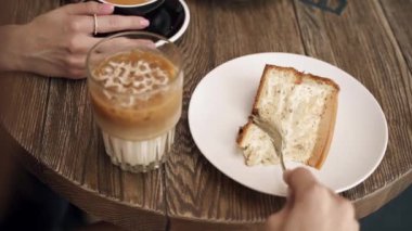 Kız bir kafede tatlı yiyor.