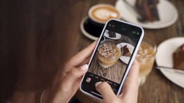 Kız telefonda kahve fotografı çekiyor.