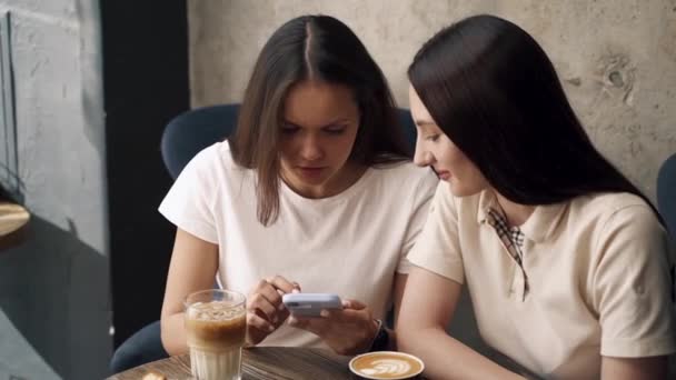 Lányok Kávézóban Ülnek Kávéznak Nézik Telefont — Stock videók