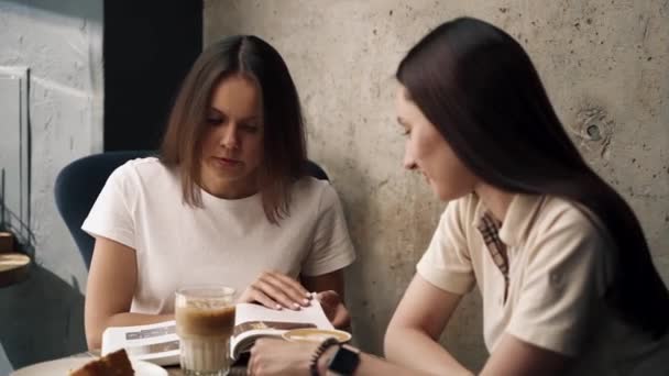 Meisjes Een Cafe Een Boek Lezen Chatten Koffie Drinken Met — Stockvideo