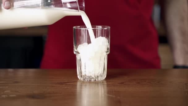 将牛奶倒入加冰的杯子中 — 图库视频影像