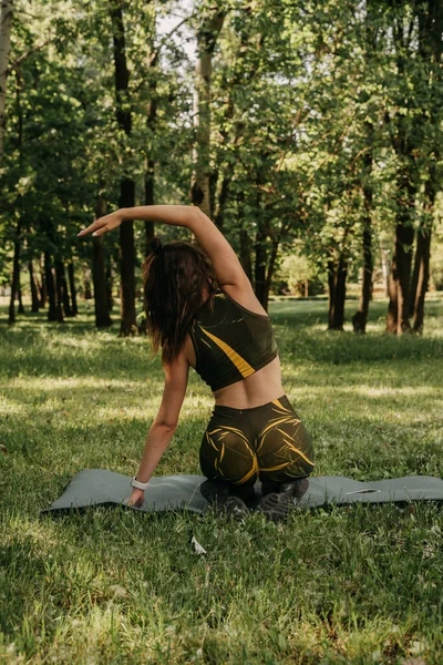 Genç bir kız spor için ormana / parka gider. # Yoga minderinde yeşil bir takım elbiseyle #