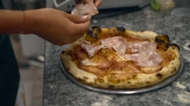 Kız restoranın mutfağında pizza hazırlıyor. büyük çerçeve