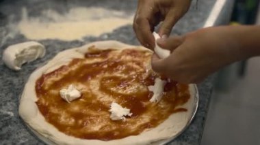 Kız restoranın mutfağında pizza hazırlıyor. büyük çerçeve