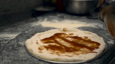 Kız restoranın mutfağında pizza hazırlıyor. büyük çerçeve